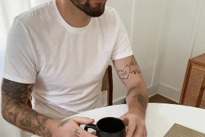 man at table holding coffee mug