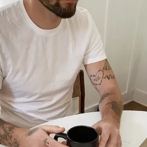 man at table holding coffee mug