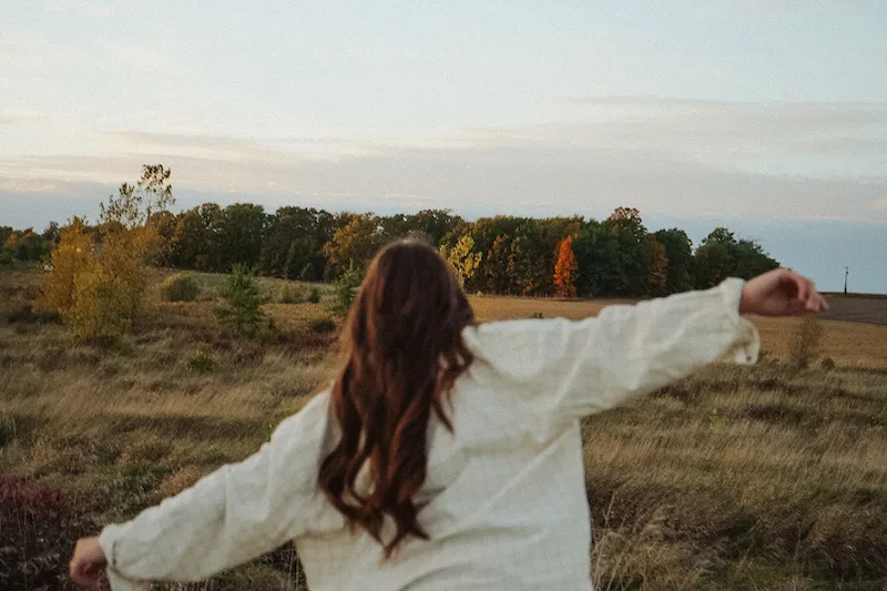 woman outdoors with arms outstretched