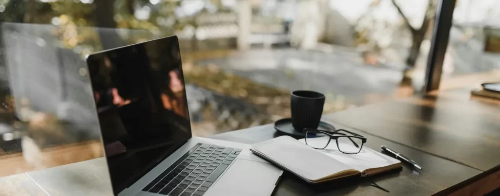 laptop on desk by large window