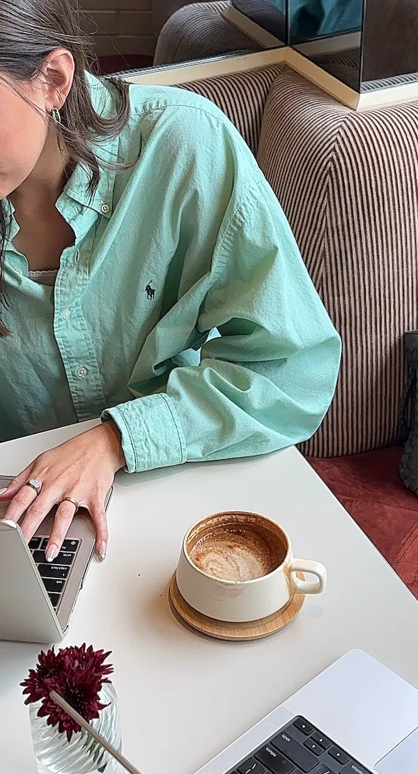 woman at table with coffee and laptop