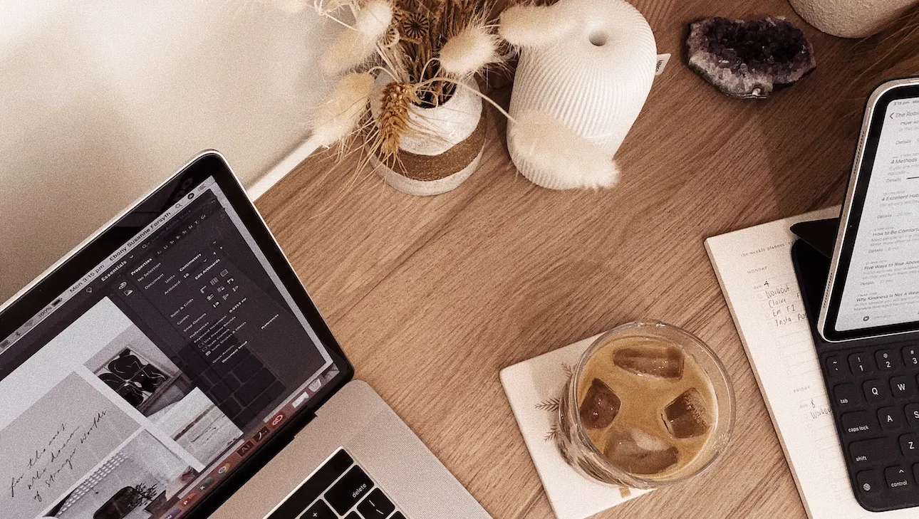 desk with laptop coffee and dried flowers