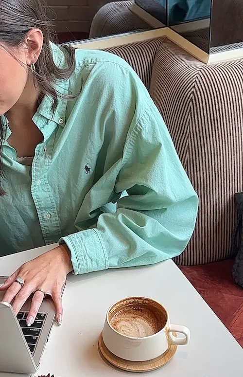 side of woman at table on laptop