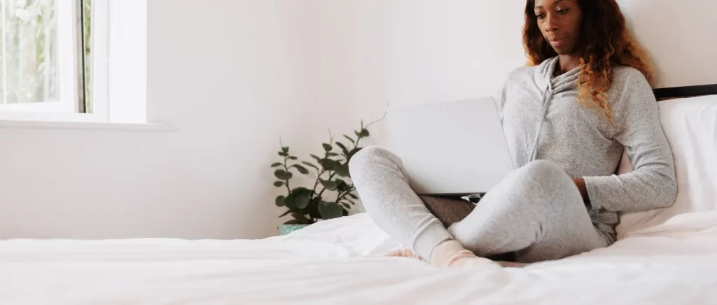 woman using laptop in bed